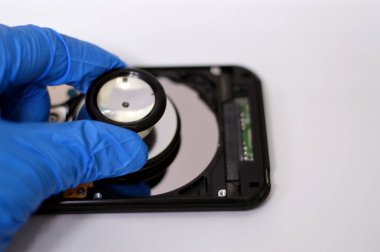 HDD plakalar ve Milli motor üzerine tıbbi steteskop, hard disk parçalanmış bileşenler, bilgisayar bakımı, çalışma, kurtarma, veri silme, veri öldürücü yazılım konsepti