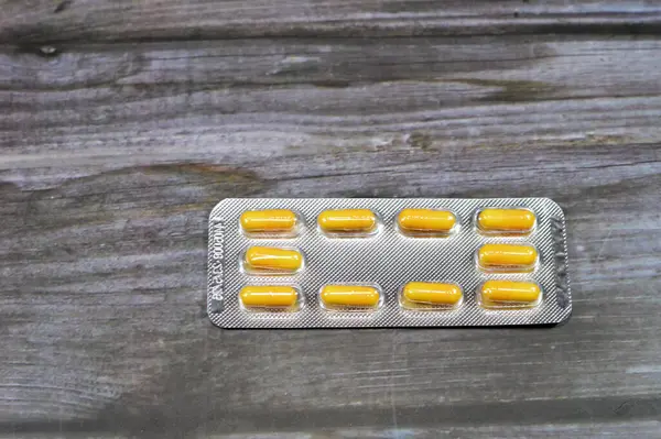 Medication capsules, yellow capsules, treatment, remedy, drug usage, abuse, prescription concept, painkillers and antibiotics, analgesics, taking a medication tablets, pill background