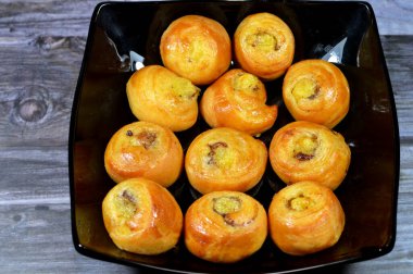 Mini tarçınlı börek, bal ve kuru üzümle tatlandırılmış ve krema ile doldurulmuş, hamur işlerinin seçici odak noktası kruvasan kruvasan fırını yalnız ve servis edilmeye hazır.