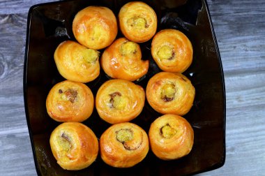 Mini tarçınlı börek, bal ve kuru üzümle tatlandırılmış ve krema ile doldurulmuş, hamur işlerinin seçici odak noktası kruvasan kruvasan fırını yalnız ve servis edilmeye hazır.