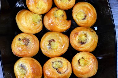 Mini tarçınlı börek, bal ve kuru üzümle tatlandırılmış ve krema ile doldurulmuş, hamur işlerinin seçici odak noktası kruvasan kruvasan fırını yalnız ve servis edilmeye hazır.