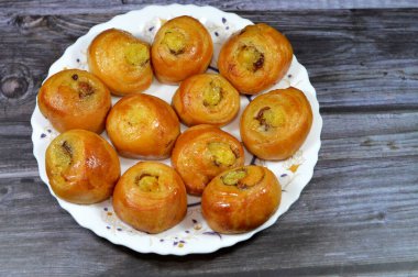 Mini tarçınlı börek, bal ve kuru üzümle tatlandırılmış ve krema ile doldurulmuş, hamur işlerinin seçici odak noktası kruvasan kruvasan fırını yalnız ve servis edilmeye hazır.