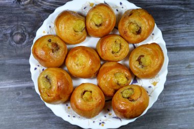 Mini tarçınlı börek, bal ve kuru üzümle tatlandırılmış ve krema ile doldurulmuş, hamur işlerinin seçici odak noktası kruvasan kruvasan fırını yalnız ve servis edilmeye hazır.