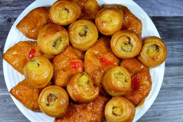 Ballı, şekerli, tatlı şuruplu, vişneli ve mini tarçınlı, ballı, kuru üzümlü ve kremalı hamur işiyle doldurulmuş Mini 'nin arka planı.