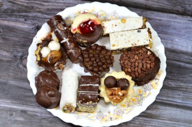 Türlü Fransız samur kurabiyeleri, tereyağı, parçalanmış, çökmüş ve farklı tatlarla kaplanmış, beyaz ve kahverengi çikolata, parçalanmış hindistan cevizi, fındık, çikolata parçaları, küçük ekmek.