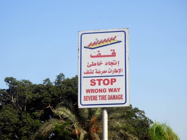 Arapça ve İngilizce uyarı levhası, Arapça sözcüklerin çevirisi (Dur, Yanlış Yol, Ağır Lastik Hasarı) bu yolda lastik hasarına yol açacak sivri bir bariyerin önünde bir uyarı olarak