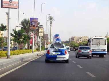 Kahire, Mısır, 20 Eylül 2023: arkasında büyük bir Red Bull konservesi olan küçük bir MINI Cooper, tüm dünyada tanıtım aracı olarak kullanıldı, bir CVT otomatik vites.