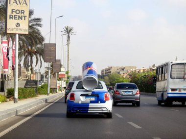 Kahire, Mısır, 20 Eylül 2023: arkasında büyük bir Red Bull konservesi olan küçük bir MINI Cooper, tüm dünyada tanıtım aracı olarak kullanıldı, bir CVT otomatik vites.