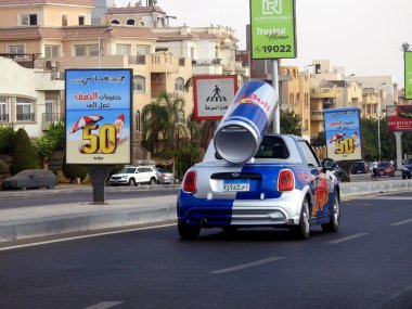 Kahire, Mısır, 20 Eylül 2023: arkasında büyük bir Red Bull konservesi olan küçük bir MINI Cooper, tüm dünyada tanıtım aracı olarak kullanıldı, bir CVT otomatik vites.