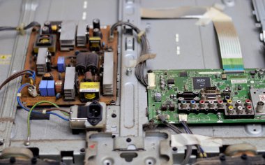 Kahire, Mısır, 26 Eylül 2023: LCD TV televizyonunun ana güç devresi, kablolar, trafolar, direniş, IC, kondansatörler, LG TV LCD 'nin elektronik devreli ana kartının onarımı