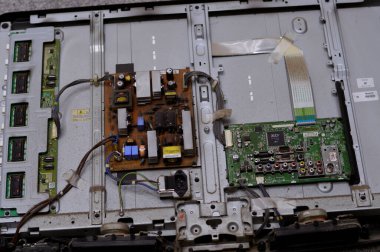 Kahire, Mısır, 26 Eylül 2023: LCD TV televizyonunun ana güç devresi, kablolar, trafolar, direniş, IC, kondansatörler, LG TV LCD 'nin elektronik devreli ana kartının onarımı