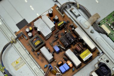 Kahire, Mısır, 26 Eylül 2023: LCD TV televizyonunun ana güç devresi, kablolar, trafolar, direniş, IC, kondansatörler, LG TV LCD 'nin elektronik devreli ana kartının onarımı