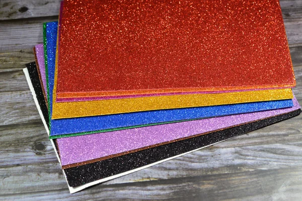 Glittered colorful Eva foam sheets, colored cardboard, rubber pad, sponge papers for school arts and crafts, pile of multicolored school board papers for children, back to school education concept