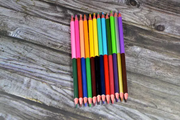 wood color pencils of different colors for painting isolated on wooden background, back to school concept, school supplies and education background, selective focus
