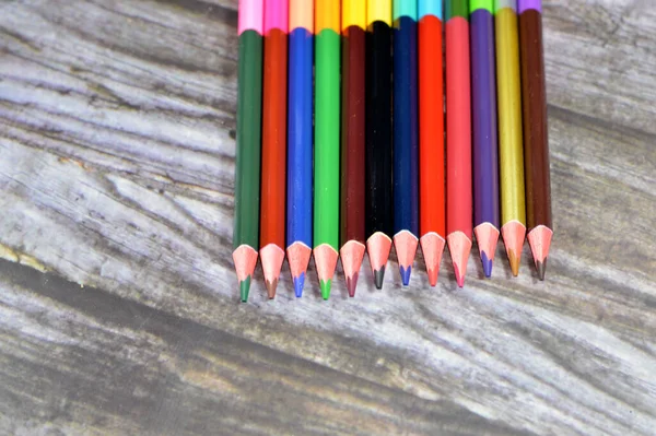 wood color pencils of different colors for painting isolated on wooden background, back to school concept, school supplies and education background, selective focus