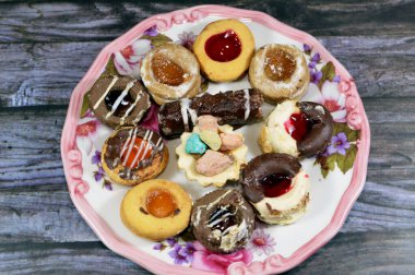 Türlü Fransız samur kurabiyeleri, tereyağı, parçalanmış, çökmüş ve farklı tatlarla kaplı, beyaz ve kahverengi çikolata, parçalanmış hindistan cevizi, reçel, küçük ekmek fırını.