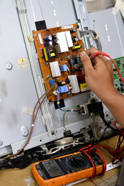 2023年10月3日 埃及开罗 一位技术工程师 使用数字万用表 液晶电视主板电路 变压器 集成电路 冷凝器 Lg主板维修 — 图库照片