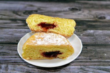 Çilek sosuyla doldurulmuş pudra şekerli donut, donut, mayalanmış hamur hamurundan yapılan bir çeşit yiyecek, genellikle un hamurundan kızartılmış, çeşitli malzemeler ve tatlar kullanılır.