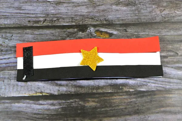 Egyptian flag colors and a star by glittered colorful Eva foam sheets, colored cardboard, rubber pad, sponge papers for school arts and crafts, pile of multicolored school board papers for children