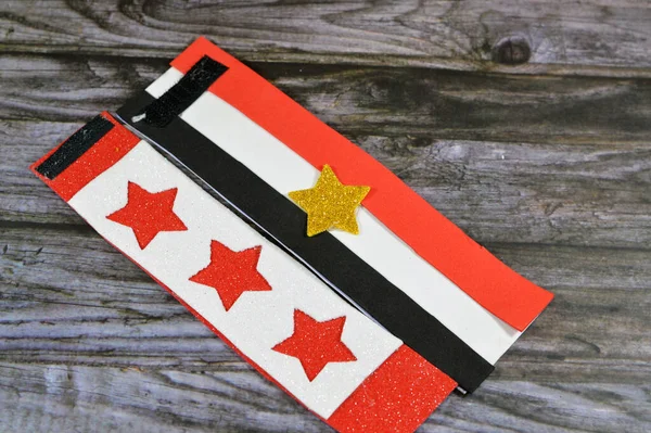Flag of Egypt colors and stars by glittered colorful Eva foam sheets, colored cardboard, rubber pad, sponge papers for school arts and crafts, pile of multicolored school board papers for children