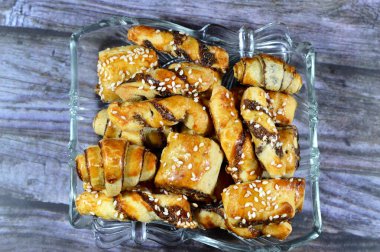 Pastry stuffed with dates and topped with sesame seeds or Ka'ab El Ghazal, Egyptian date or Agwa Ajwa filled cookies, famous middle eastern date filled pastries covered with sesame, selective focus clipart