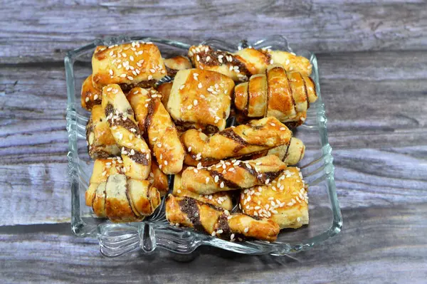 stock image Pastry stuffed with dates and topped with sesame seeds or Ka'ab El Ghazal, Egyptian date or Agwa Ajwa filled cookies, famous middle eastern date filled pastries covered with sesame, selective focus