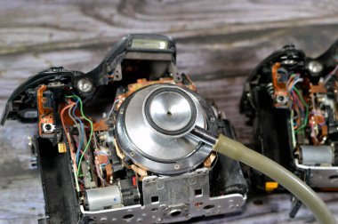 Bir DSLR fotoğraf ve video dijital kamera gövdesi üzerinde tıbbi steteskop iç onarım, kamera ve teknoloji ekipmanları bakım ve onarım konsepti, eski SLR ekin ekin aynası aynası kamera sabitlemesi