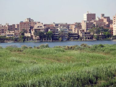 Giza, Mısır, 9 Eylül 2022: Mısır 'daki Nil nehri, kıyısında Giza' da bir köy binası olan Nil Nehri, kuzeydoğu Afrika 'da büyük bir nehir olup Akdeniz' e akar.