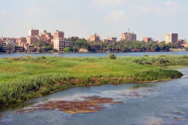 Giza, Mısır, 9 Eylül 2022: Mısır 'daki Nil nehri, kıyısında Giza' da bir köy binası olan Nil Nehri, kuzeydoğu Afrika 'da büyük bir nehir olup Akdeniz' e akar.