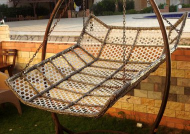 Bir bahçe sallanan hamak metal yatak, kumaştan, metalden yapılmış ve iki ya da daha fazla noktanın arasına asılmış, sallanmak, uyumak ya da dinlenmek için kullanılan bir askı, yazın, dinlenmenin bir sembolü,