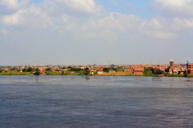 Giza, Mısır, 9 Eylül 2022: Mısır 'daki Nil nehri, kıyısında Giza' da bir köy binası olan Nil Nehri, kuzeydoğu Afrika 'da büyük bir nehir olup Akdeniz' e akar.