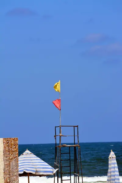 Yellow and red flags on the beach, beach warning flag system, red flag means High risk, rough conditions, strong surf, and currents, Yellow flag means Medium risk, light surf currents, lifeguard