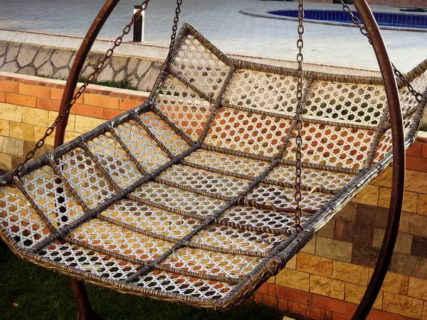 A garden swing hammock metal bed, a sling made of fabric, metal and suspended between two or more points, used for swinging, sleeping, or resting, a symbol of summer, leisure, relaxation