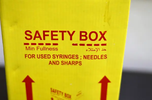 Translation of Arabic text (Fullness level), a safety box contains medical waste of sharp needles, syringes, dangerous sharp used objects, broken ampoules and other hazardous objects in side a bin