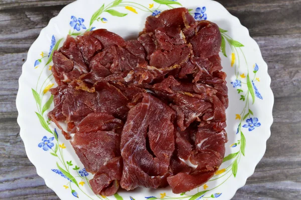 Thin slices of beef pastrami, made from beef brisket, raw meat is brined, partially dried, seasoned with herbs and spices, then smoked and steamed, like corned beef, originating from Romania