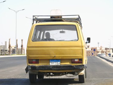Kahire, Mısır, 23 Eylül 2022: Eski eski küçük bir otomobil, yeni Mısır plakalı bir mikrootobüs, eski bir antika araba, tarihi bir araba, seçici odaklı.