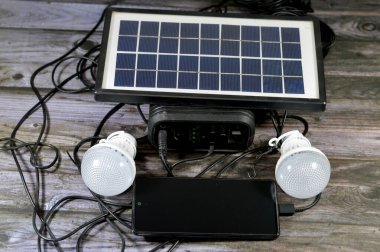 Bir güneş paneli ile yüklü çok amaçlı bir pil, fotovoltaik (PV) hücreler kullanarak güneş ışığını elektriğe dönüştüren bir cihaz, cep telefonunu USB portu üzerinden şarj eden ve bağlı yönlendirilmiş ışık