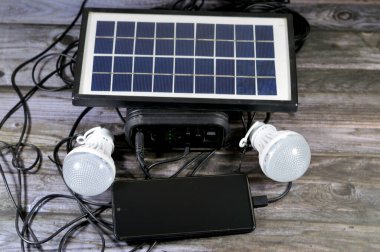 Bir güneş paneli ile yüklü çok amaçlı bir pil, fotovoltaik (PV) hücreler kullanarak güneş ışığını elektriğe dönüştüren bir cihaz, cep telefonunu USB portu üzerinden şarj eden ve bağlı yönlendirilmiş ışık