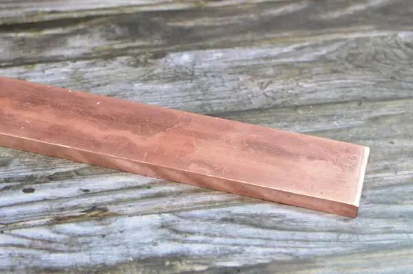 Long heavy copper bar, Copper is a mineral, an element and a metal, used in wiring, roofing, pipes, pots and pans, decorations and artworks, jewelry and coins, Cu atomic number is 29, Red copper
