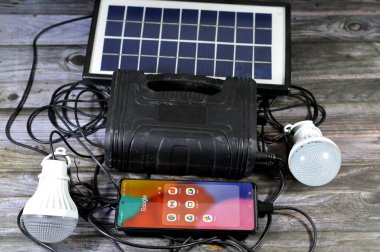 Kahire, Mısır, 6 Kasım 2023: GDLAGEN GD35wp güneş ışığı kiti, çok fonksiyonlu mini güneş evi aydınlatma sistemi, güneş paneli cihazı, Samsung cep telefonunu google uygulamaları ile dolduruyor