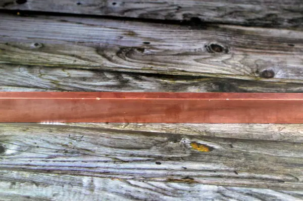 Long heavy copper bar, Copper is a mineral, an element and a metal, used in wiring, roofing, pipes, pots and pans, decorations and artworks, jewelry and coins, Cu atomic number is 29, Red copper