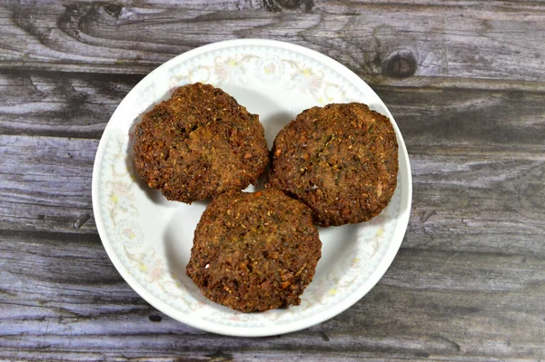 stock image Traditional Egyptian fried falafel balls, green burger, made of ground chickpeas and broad beans, deep fried balls or patty-shaped fritter, with sesame, fried in deep oil and served in a plate