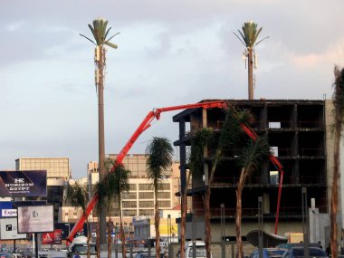 Kahire, Mısır 14 Kasım 2023: Yolun kenarında yeni binaya beton döken kamyon destekli bir patlama pompası, yeni inşaat alanındaki beton kamyonun seçici odak noktası