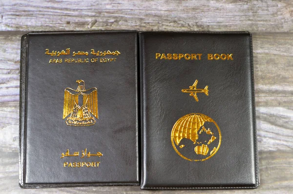 Egyptian passport black book, Translation of Arabic words (Arab republic of Egypt\'s passport) and Black passport book with a plane and the globe earth on its cover, travel and tourism concept
