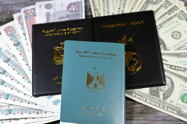 Egyptian passport black book, Translation of Arabic words (Arab republic of Egypt\'s passport) and Black passport book with Egyptian pounds and American dollars cash money banknotes, Travel concept