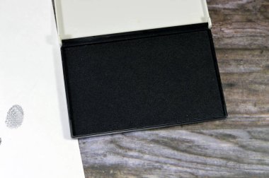 Bir parmak izi ve siyah renk mürekkep bloknotu, parmak izi, adli tıpta önemli bir olay yerinden kısmi parmak izlerinin alınması ve insan parmağının sürtünme sırtlarında bıraktığı bir iz.