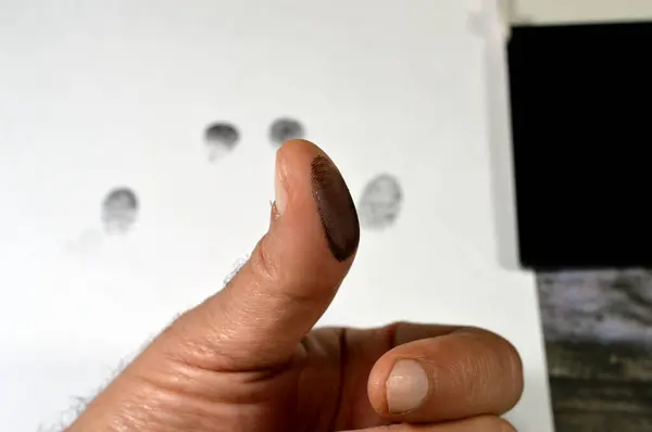A fingerprint  and a black color stamp ink pad, finger print is an impression left by the friction ridges of a human finger, recovery of partial fingerprints from a crime scene important in forensic