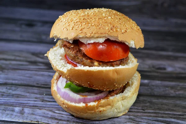 spicy fried beef burger cooked in a boiling shallow oil with slices of  tomatoes, onions, bell peppers in burger bun topped with sesame seeds, Fast food, Junk food concept, beef meat burger sandwich