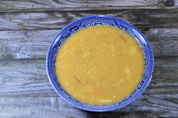 Lentil soup, a soup with lentils as its main ingredient, may include vegetables such as carrots, potatoes, celery, parsley, tomato, pumpkin, ripe plantain, vermicelli and onion, selective focus