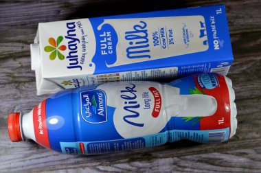 Kahire, Mısır, 16 Aralık 2023: Almarai tam yağlı, koruyucu içermeyen inek sütü, D vitamini olmayan toz, Juhayna tam kremalı, kalsiyum ve vitaminli inek sütü kutusu